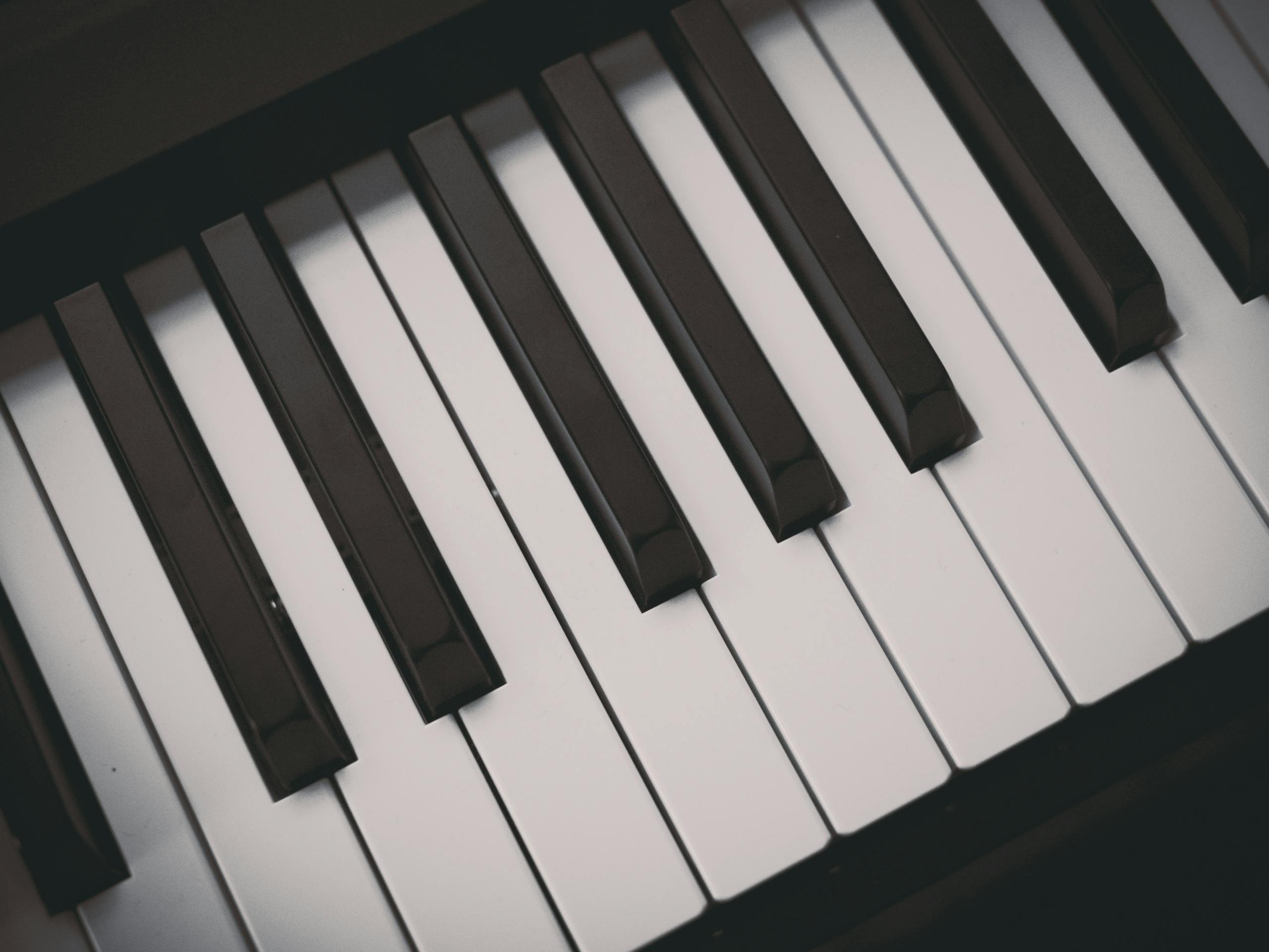 A detailed close-up image of black and white piano keys, showcasing musical elegance.
